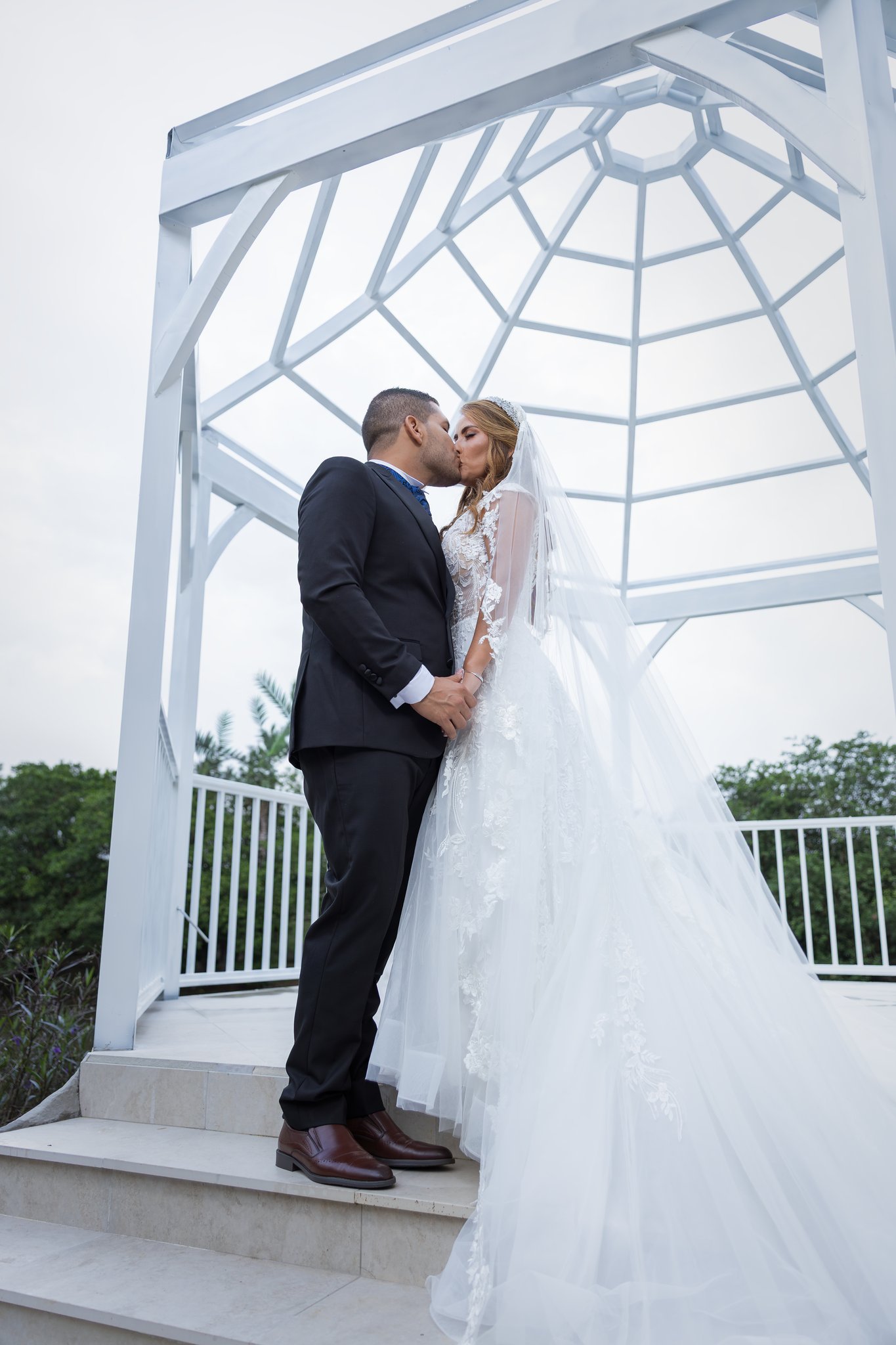 Pareja de novios en sesión romántica bajo pérgola