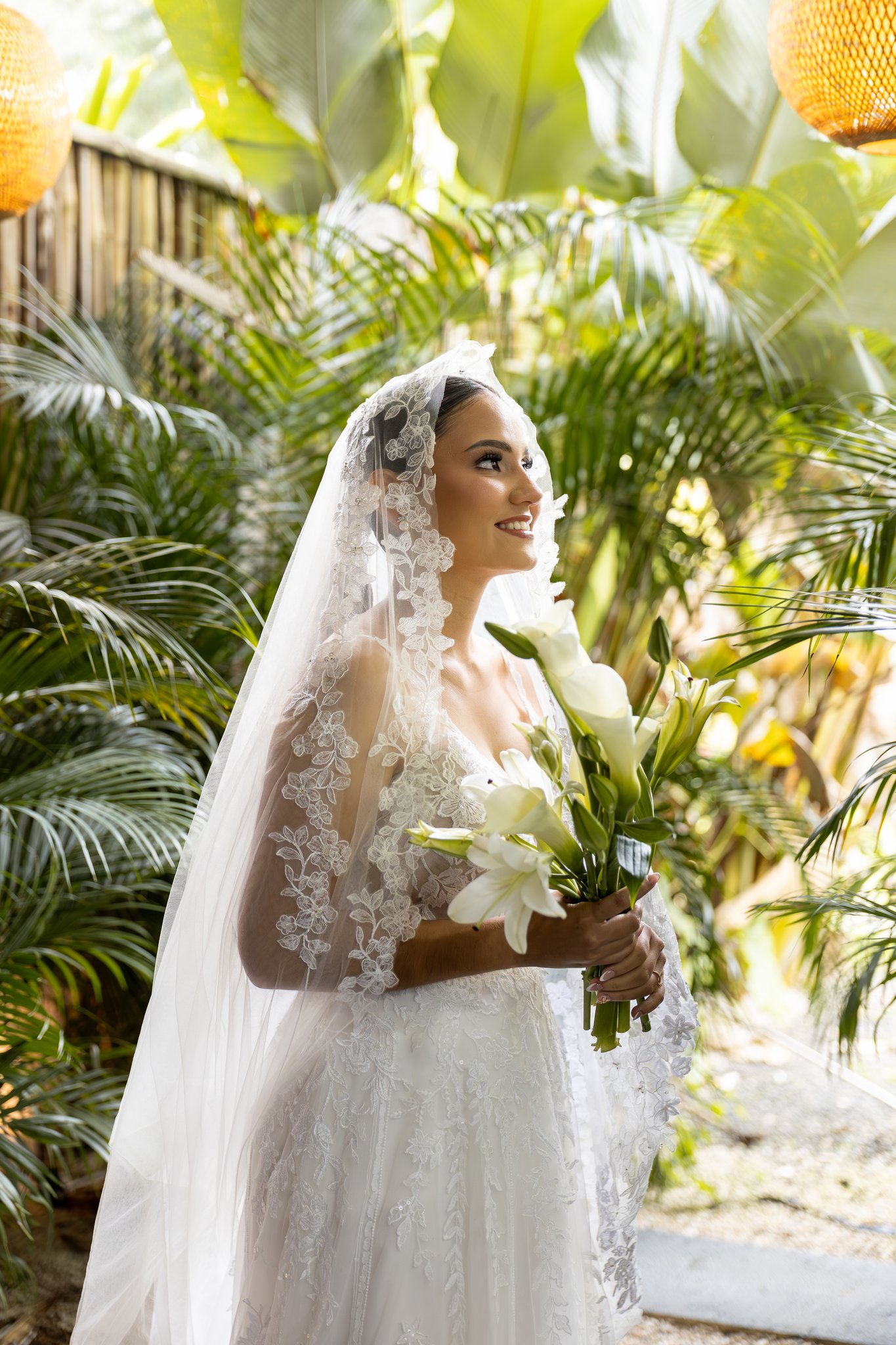 Novia con ramo de flores blancas en jardín tropical